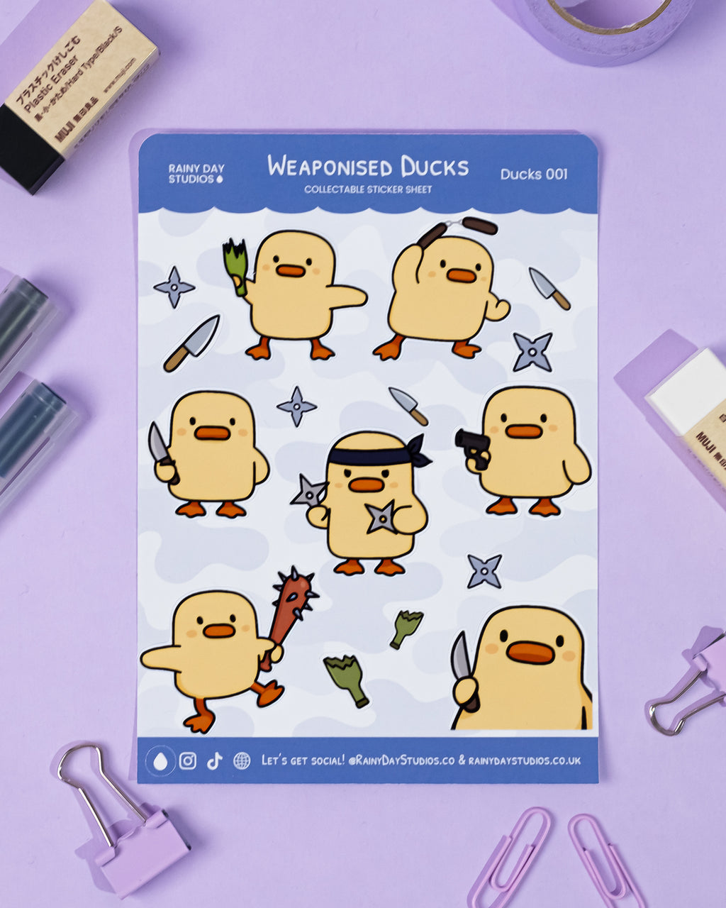 Sheet of 'Weaponised Ducks' stickers by Rainy Day Studios on a purple background with stationery items.