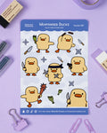 Sheet of 'Weaponised Ducks' stickers by Rainy Day Studios on a purple background with stationery items.